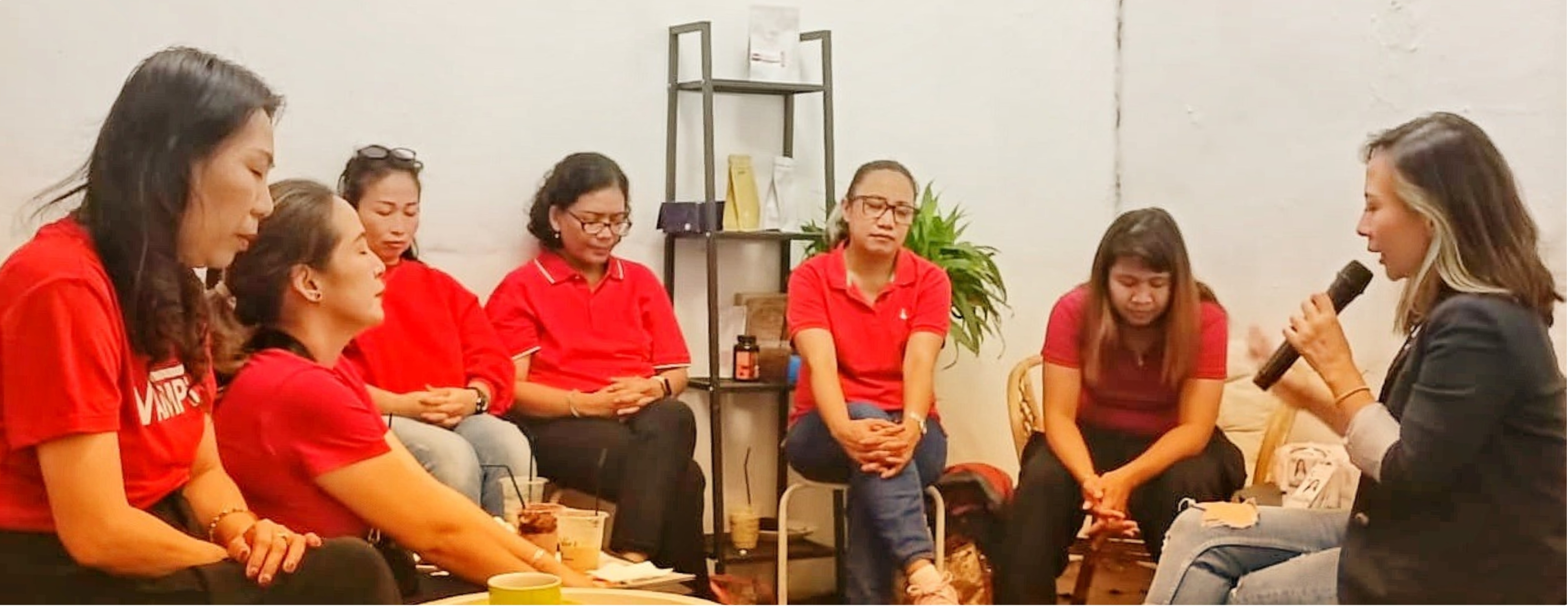 Pembicara sedang mempresentasikan materi di hadapan peserta berbaju merah